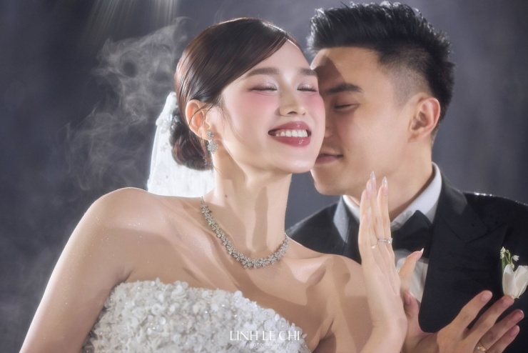 Cả hai giơ cao bàn tay đeo nhẫn cưới về phía khách mời để chia sẻ niềm hạnh phúc. Ảnh: Linh Lê Chí