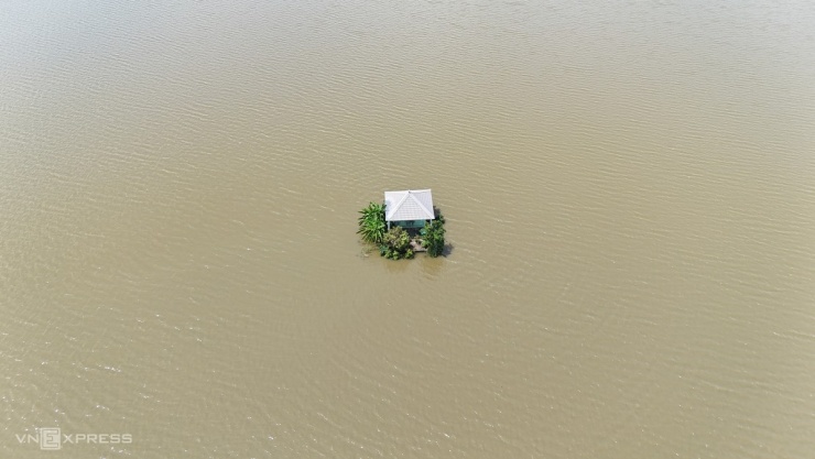 Căn nhà mồ bị ngập nền, nằm chơ vơ giữa cánh đồng nước dâng hơn 2 m.