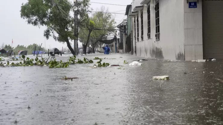 Người dân vật lộn trong dòng nước lũ. Ảnh: NGUYỄN DO