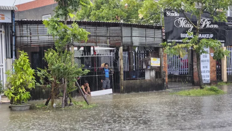 Người dân sử dụng các vật dụng chặn nước tràn vào nhà. Ảnh: NGUYỄN DO