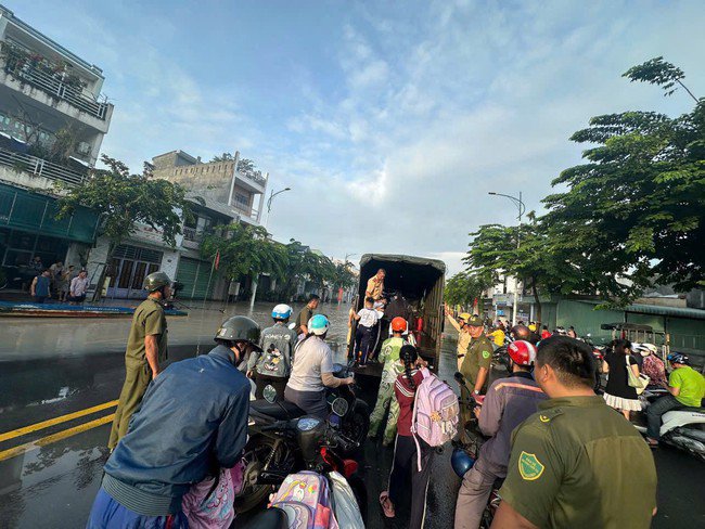 Lực lượng CSGT hỗ trợ người dân đi qua điểm ngập