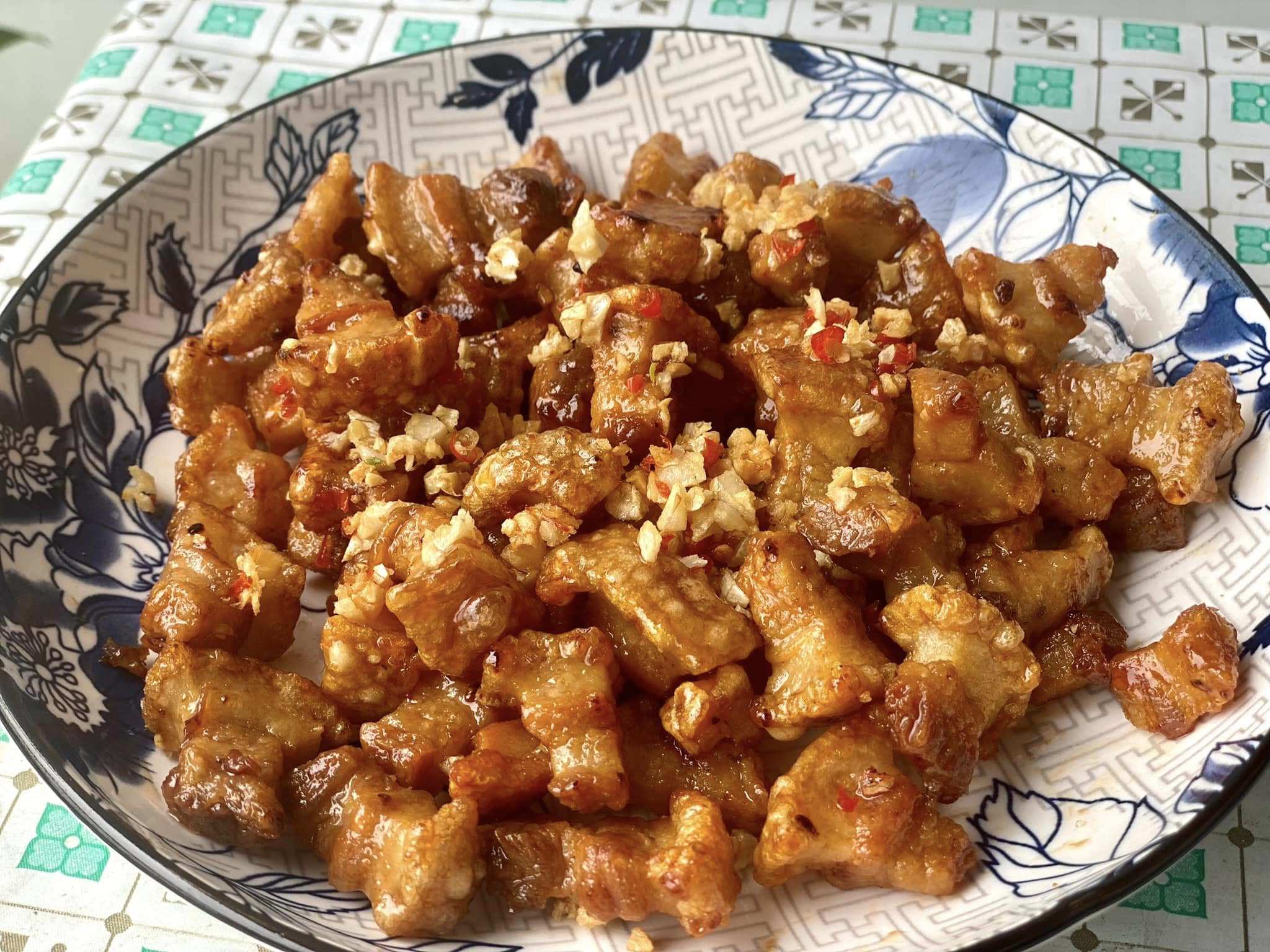 Cho nước sốt vào đun sôi, đến khi nước sốt sệt lại thì cho tóp mỡ vào đảo đều, rắc thêm một chút ớt bột là hoàn thành.&nbsp;
