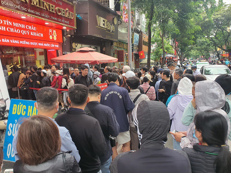 Người dân xếp hàng mua vàng kín vỉa hè, xuống cả lòng đường, che hết lối đi của một số cửa hàng bên cạnh.