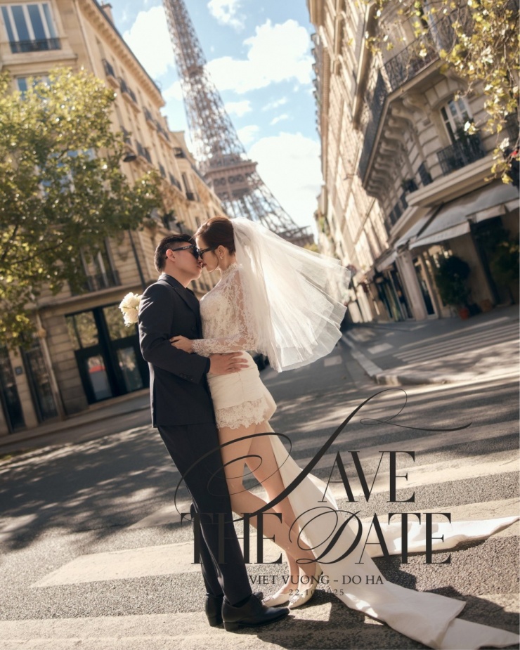 Họ tình tứ trên một con phố nổi tiếng của Paris với tháp Eiffel phía sau. Mỹ nhân diện kiểu váy ren năng động kết hợp khăn voan, tà dài tạo điểm nhấn.