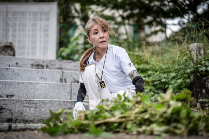Cựu yakuza Mako đang phân loại lá rụng trong hoạt động dọn dẹp tại đền Gifu ngày 28/9. Ảnh: AFP