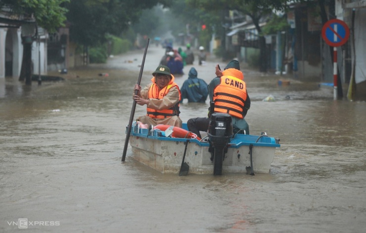 Đường Nguyễn Chí Thanh đoạn qua phường Phú Xuân ngập sâu hơn một mét. Người dân muốn di chuyển phải đi thuyền hoặc lội nước.
