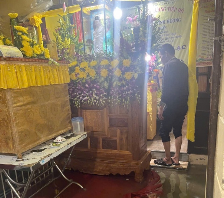 Một đám tang khác ở đường Chi Lăng (phường Phú Xuân) cũng được công an hỗ trợ gia quyến đưa quan tài lên cao tránh lụt. Ảnh: Công an cung cấp.