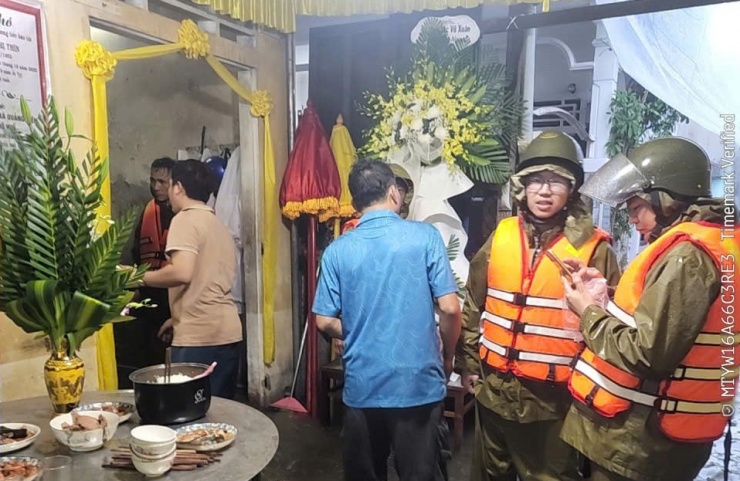 Công an phường Phú Xuân đến hỗ trợ một gia đình tang quyến bị ngập lụt.