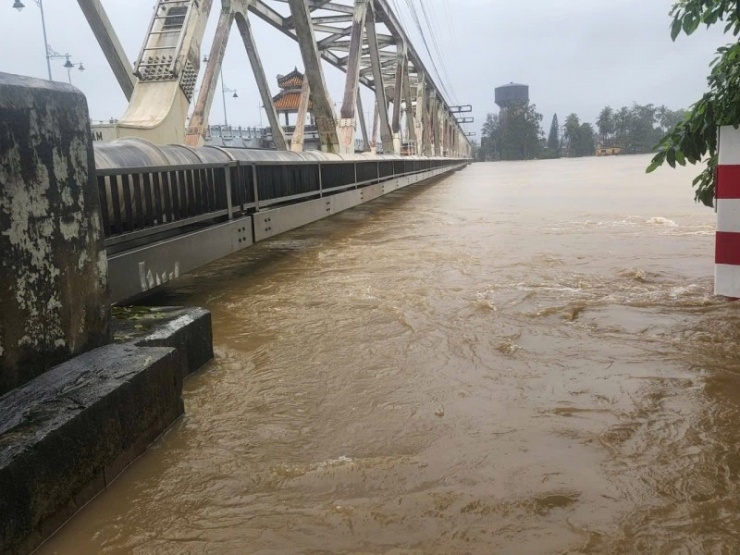 Mực nước trên sông ngày một dâng cao sát mặt cầu đường sắt.  