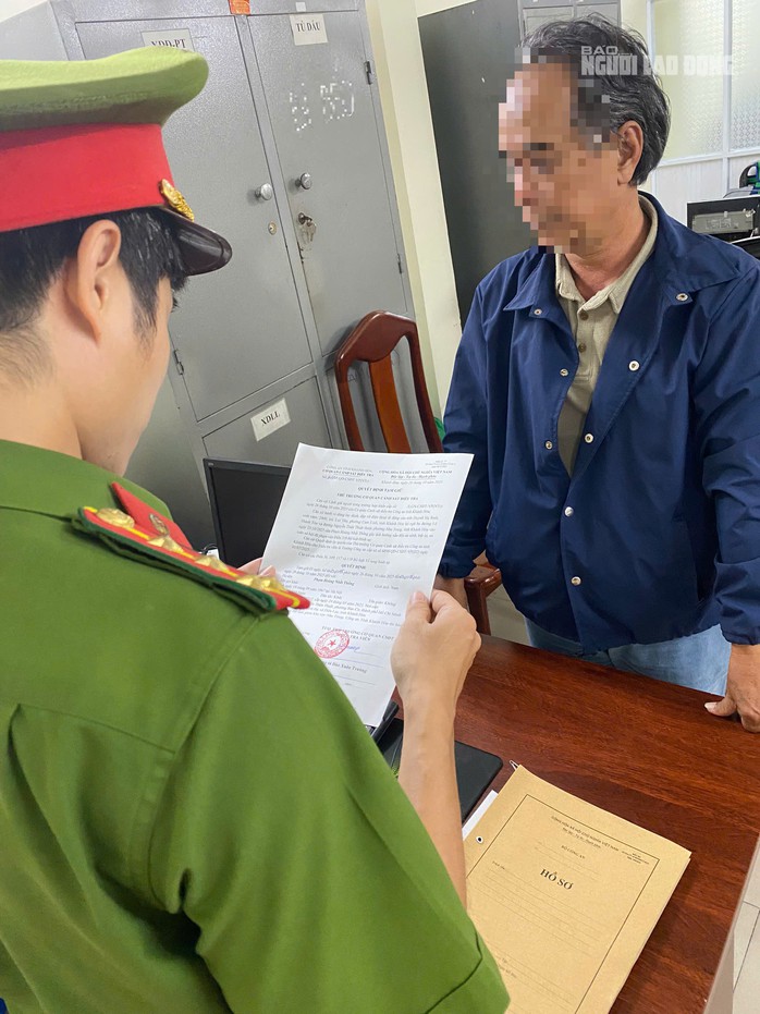 Công an đọc quyết định tạm giữ ông Th. để làm rõ hành vi đánh tài xế taxi Xanh, ảnh: CQCN