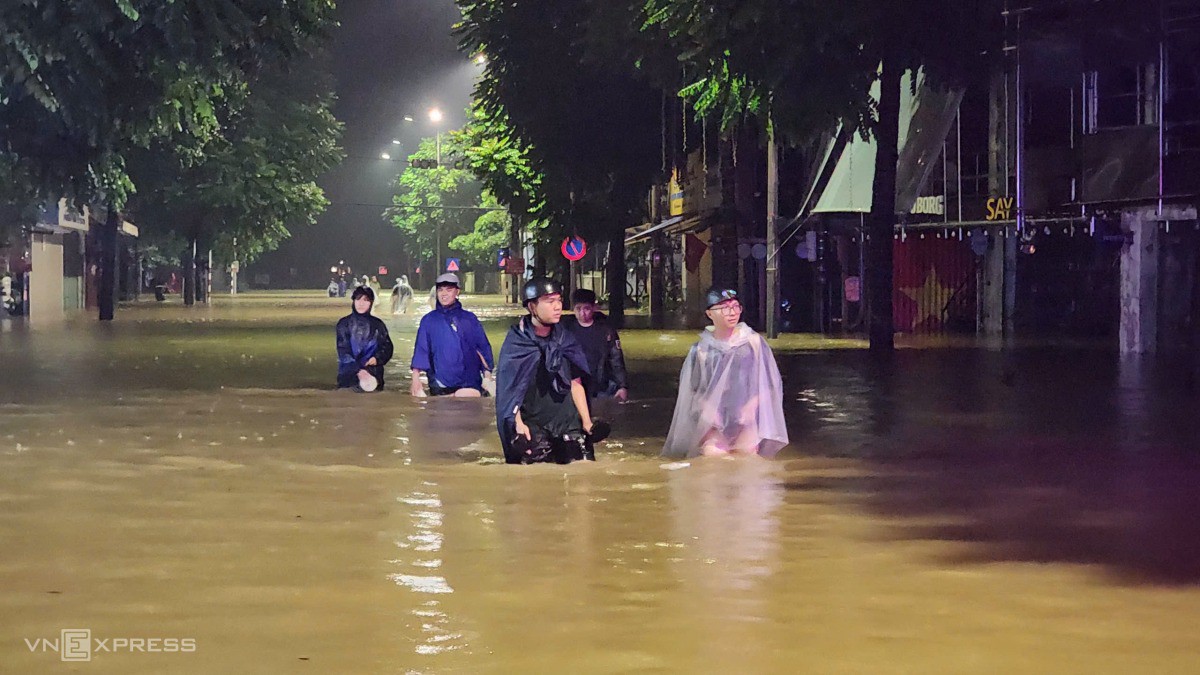 Phố biến thành sông, người dân phải lội nước về nhà. Hôm nay, toàn bộ học sinh TP Huế được nghỉ học. Ảnh: Võ Thạnh