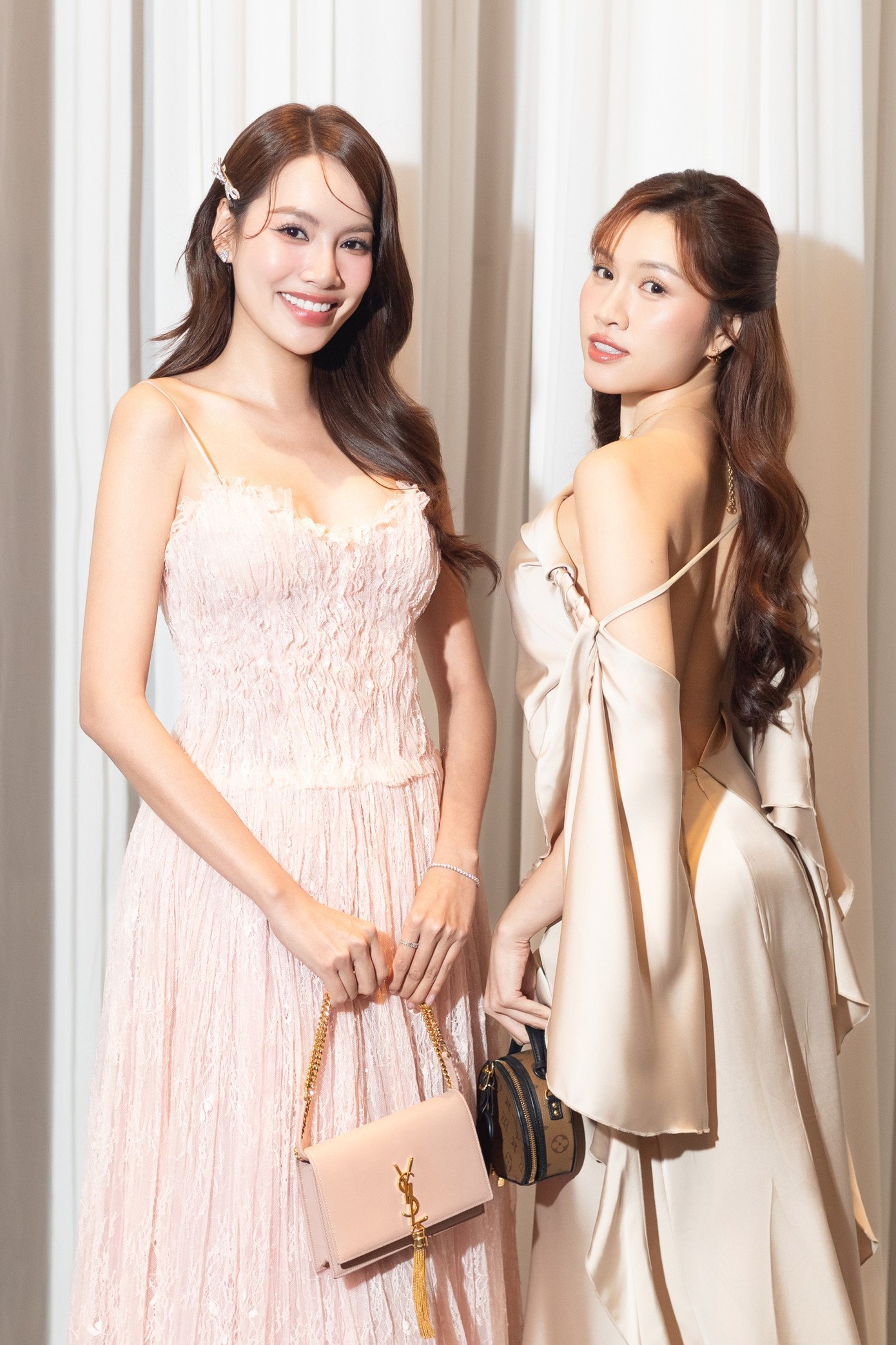 Hoa hậu Lê Hoàng Phương diện váy quây tông hồng phấn, kết hợp phụ kiện đồng màu tạo tổng thể nhẹ nhàng, thanh lịch. MC Thanh Thanh Huyền chọn váy lụa xẻ lưng màu champagne, khoe vai trần. Cả hai đều diện nguyên cây hàng hiệu, xuất hiện nổi bật.