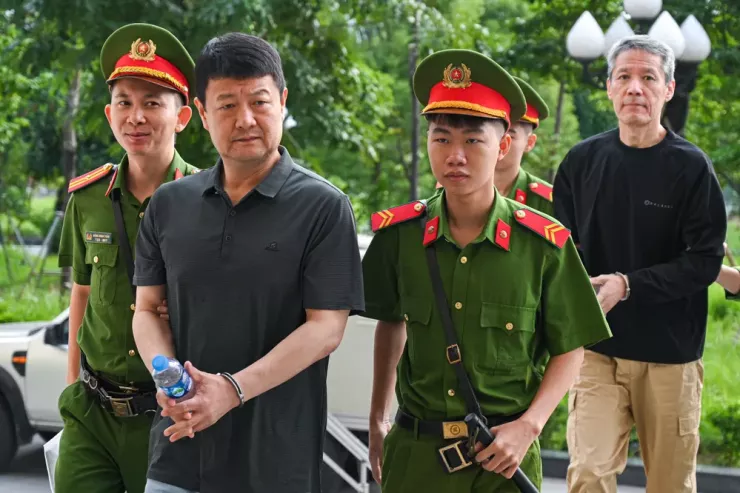 Lực lượng chức năng dẫn giải các bị cáo tới phiên tòa. Ảnh: Hoàng Huy