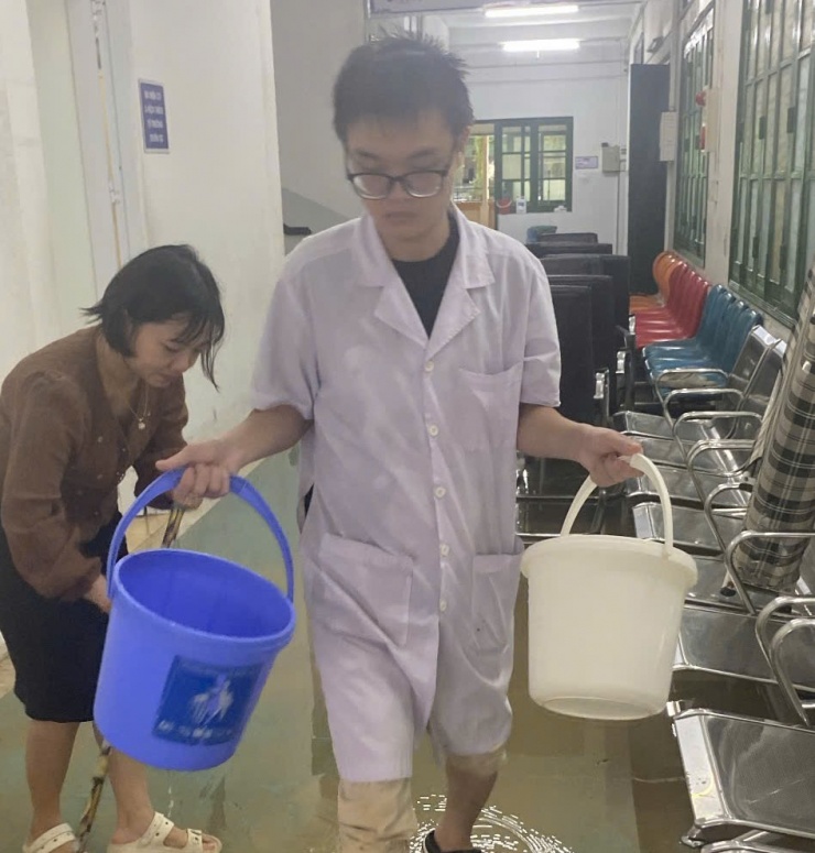 Nhân viên xách nước đến dội rửa khu vực ngập lụt.