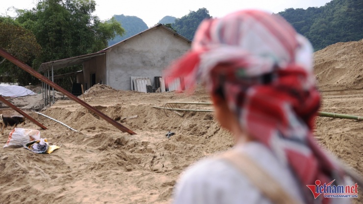Bà Yêu tiếc nuối nhìn về căn nhà vừa được xây năm ngoái hiện đã bị vùi lấp quá nửa, không thể tiếp tục sử dụng. Ảnh: Đức Hoàng