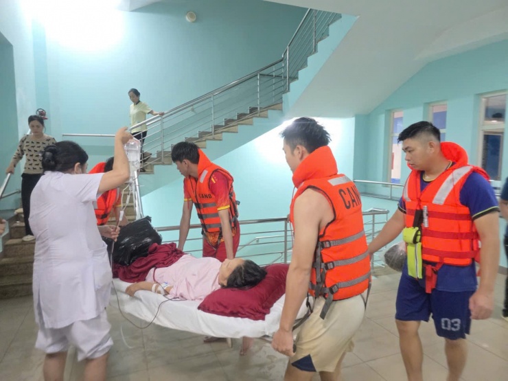 Lực lượng chức năng và nhân viên y tế di dời bệnh nhân đang điều trị tại Bệnh viện Trung ương Huế ra khỏi khu vực ngập lụt lên tầng cao hơn.