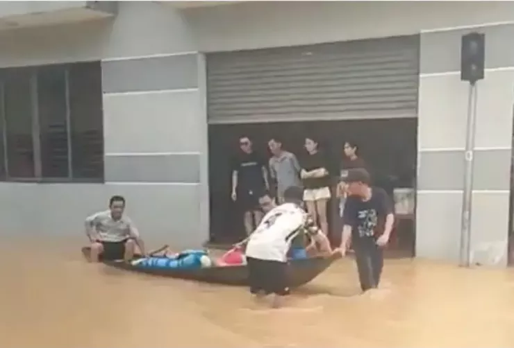 Đưa các nạn nhân trong gia đình ngạt khí ra khỏi khu vực ngập để cấp cứu.