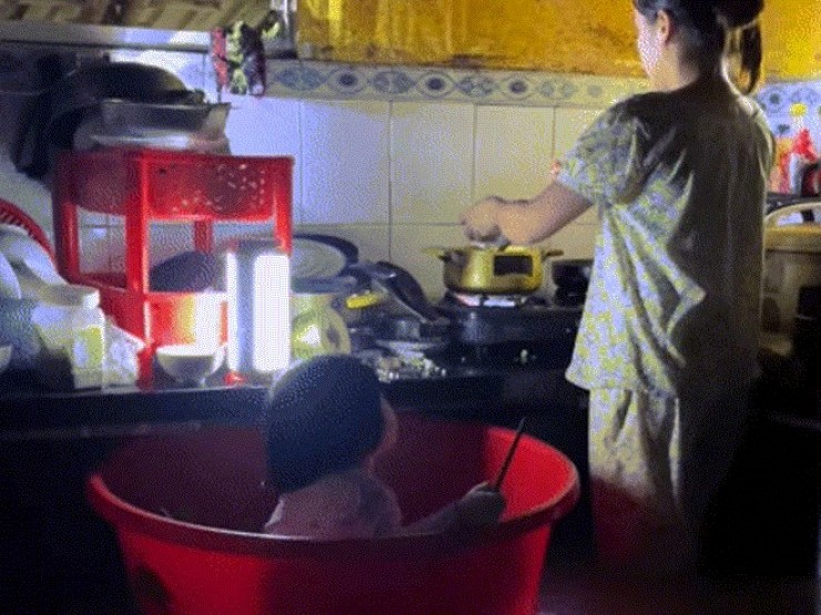 Đà Nẵng ngập lụt, mẹ trẻ đặt con vào chậu vừa trông vừa nấu vội bữa cơm chiều