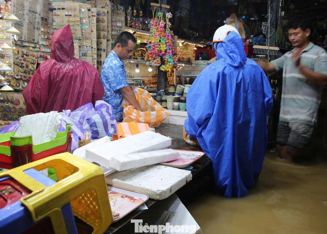 Nước lũ tràn vào nhà, hàng quán, người dân phải tạm ngưng kinh doanh, dọn dẹp hàng hóa đưa lên cao tránh lũ