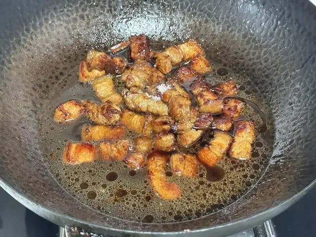 Cho một nắm đường phèn vào, xào để tạo màu caramen. Đảo đều thịt và đường phèn. Tiếp theo, cho vào 1 cái hoa hồi, 1 ít quế, 2 thìa nước tương, 2 thìa hắc xì đầu, một chút bột tiêu trắng, một chút bột gừng và chút muối. Đảo đều.