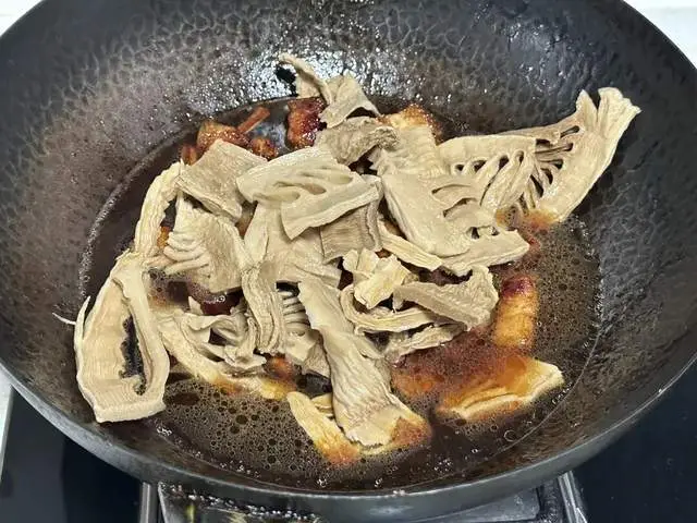 Cho nước vào, đảm bảo nước ngập xăm xắp mặt thịt và các nguyên liệu. Cho măng đã ngâm mềm vào nồi.