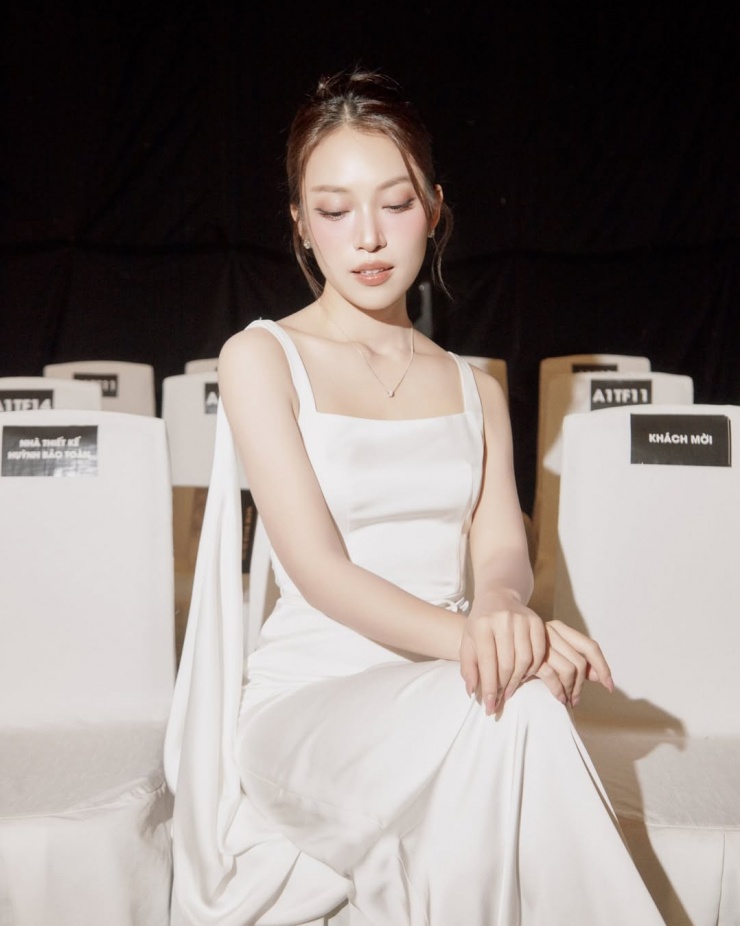 Khi làm MC cho show của nhà thiết kế Hà Thanh Việt, cô chọn đầm chữ A tối giản bằng satin, nhấn bằng dải lụa dài chạy từ vai.