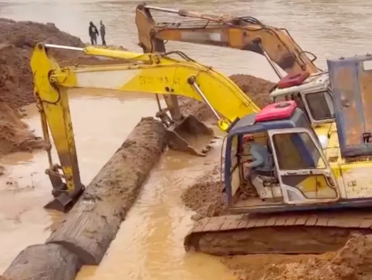 Hai xe múc được huy động đào bờ sông Ayun, đoạn qua thôn Plei Kual, xã Phú Thiện để khai thác, trục vớt cây gỗ lạ chìm sâu trong đất.