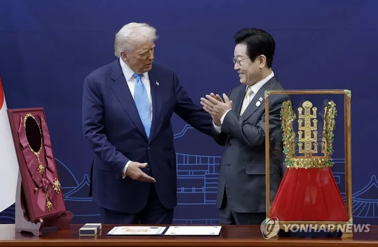 Tổng thống Hàn Quốc Lee Jae-myung (phải) trao tặng Tổng thống Mỹ Donald Trump bản sao chiếc vương miện Cheonmachong cùng Huân chương Đại Mugunghwa trong lễ đón tại TP Gyeongju (Hàn Quốc) ngày 29-10. Ảnh: YONHAP