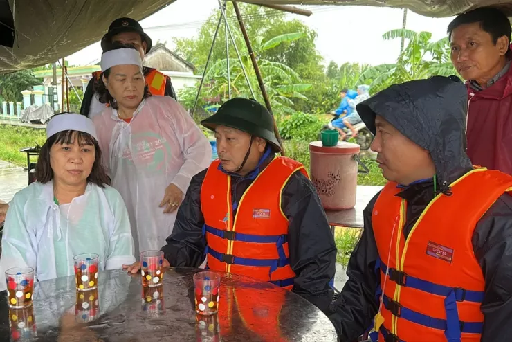 Trên đường đi tiếp ứng, ông Nguyễn Hảo (chính giữa), Bí thư xã Đại Lộc đến viếng hương, chia buồn với gia đình cụ bà mất giữa lúc ngập lụt, gia đình không thể tổ chức đám tang ở nhà. Ảnh: THANH NHẬT