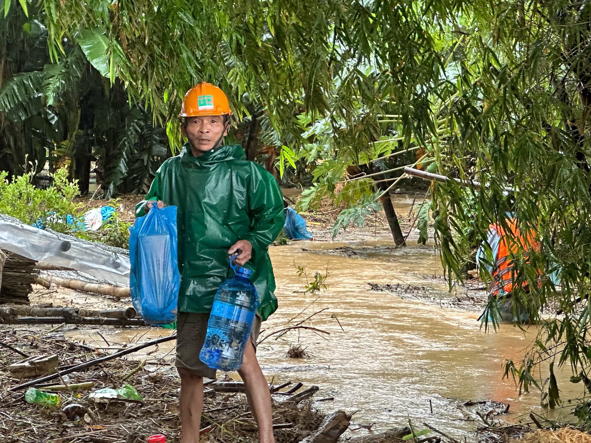 Ông Trần Khương vẫy tay gọi ca nô tiếp tế thức ăn, nước uống. Ảnh: THANH NHẬT