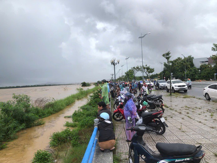 Nhiều người dân đang xem lực lượng chức năng giải cứu 8 người dân đang mắc kẹt giữa dòng nước lũ sông Trà Khúc