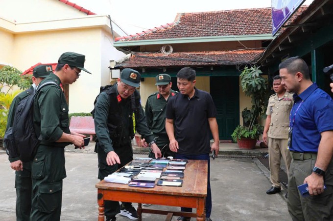 Công an kiểm tra tang vật lừa đảo qua mạng. Ảnh: Linh Đan
