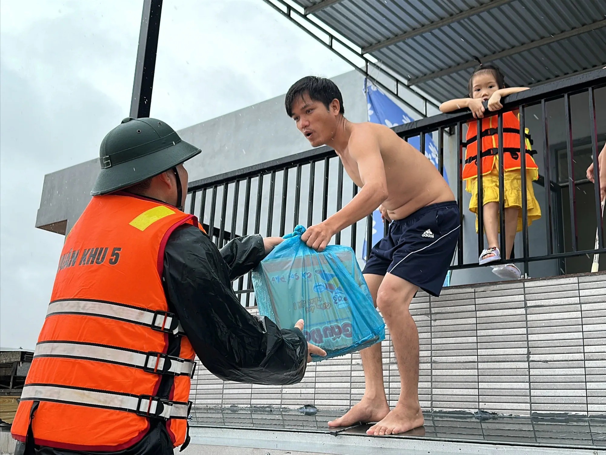 Chồng chị Lai nhận mì tôm dùm hàng xóm. Ảnh: THANH NHẬT