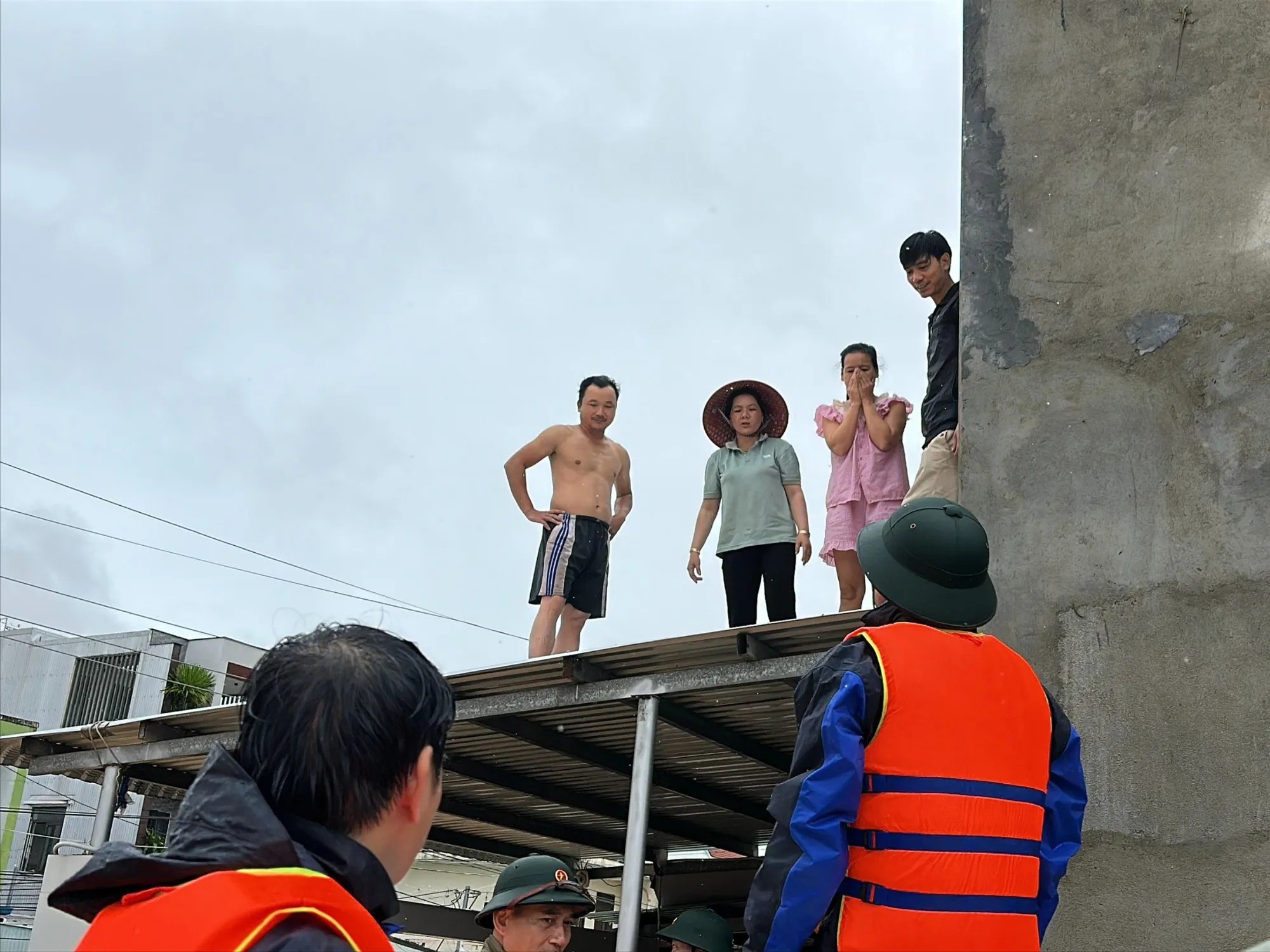 Ông Nguyễn Hảo (mặc áo phao) tiếp tế thức ăn cho người dân vùng rốn lũ. Ảnh: THANH NHẬT