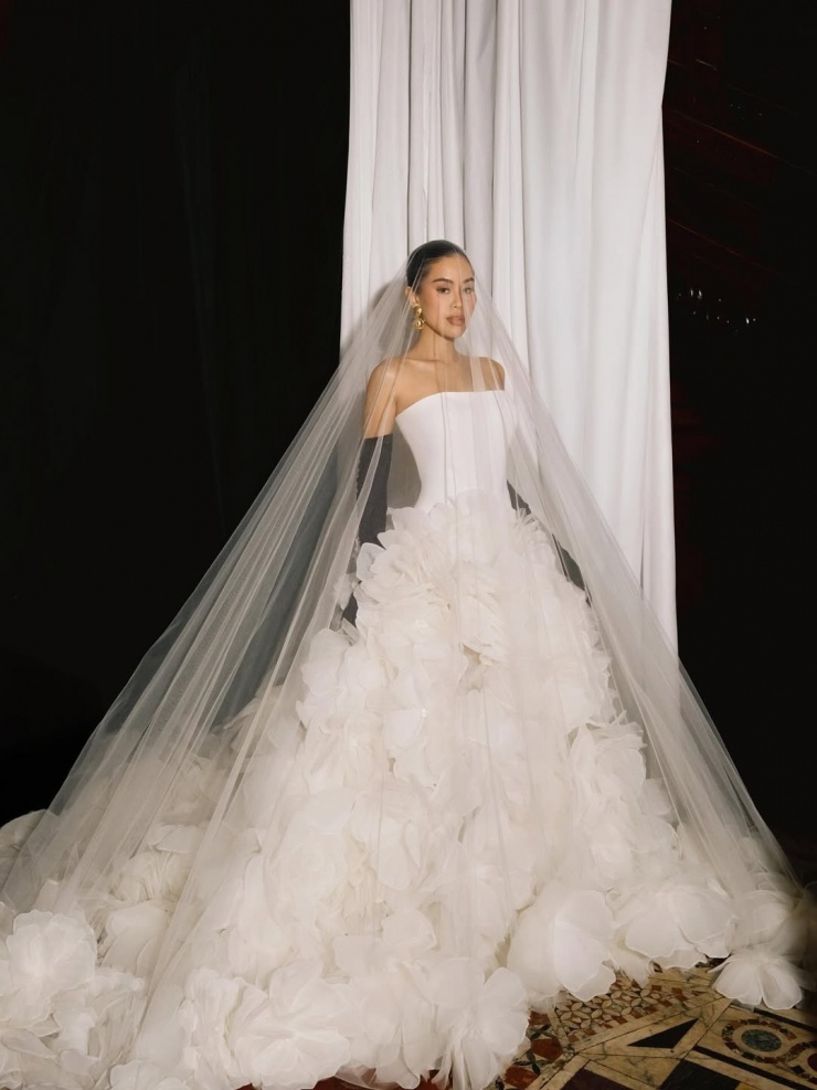 Tiên Nguyễn sử dụng khăn voan rộng phủ khắp người, kết hợp găng tay, búi tóc cao.