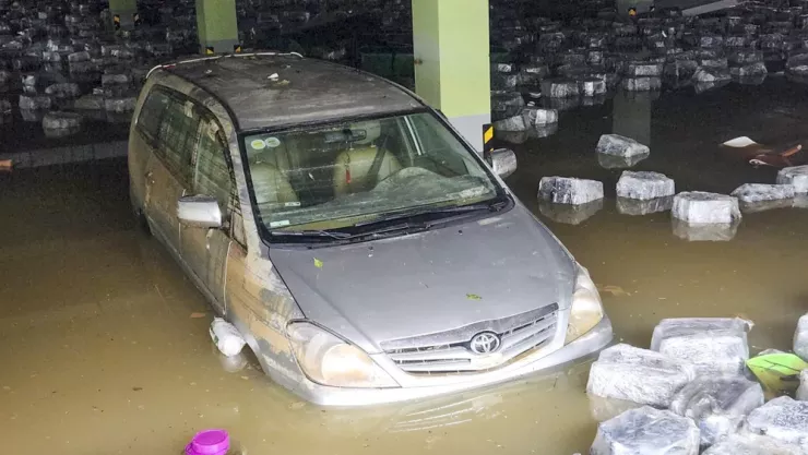 Bùn đất bao phủ xe khi nước được hút bớt khỏi hầm.