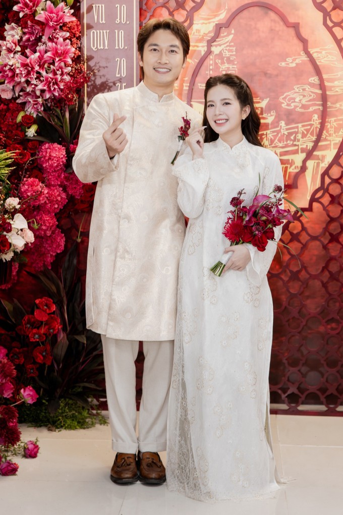 Lễ ăn hỏi và lễ vu quy của Đình Tú - Ngọc Huyền diễn ra tại tư gia nhà gái sáng 30/10. Cặp diễn viên giờ vàng VTV chọn áo dài gấm màu đồng điệu khi làm cô dâu, chú rể.