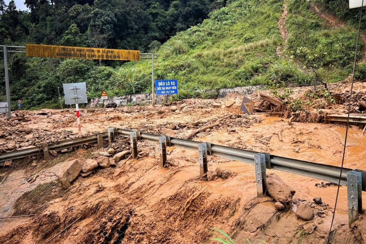 Đất đá sạt xuống vùi lấp mặt đường trên đèo Lò Xo, khiến hàng chục tài xế phải mắc kẹt giữa mưa lũ.