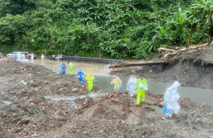 Lực lượng chức năng và tình nguyện viên lội bùn, băng qua các điểm sạt lở để tiếp tế lương thực cho các tài xế bị cô lập trên đèo Lò Xo.