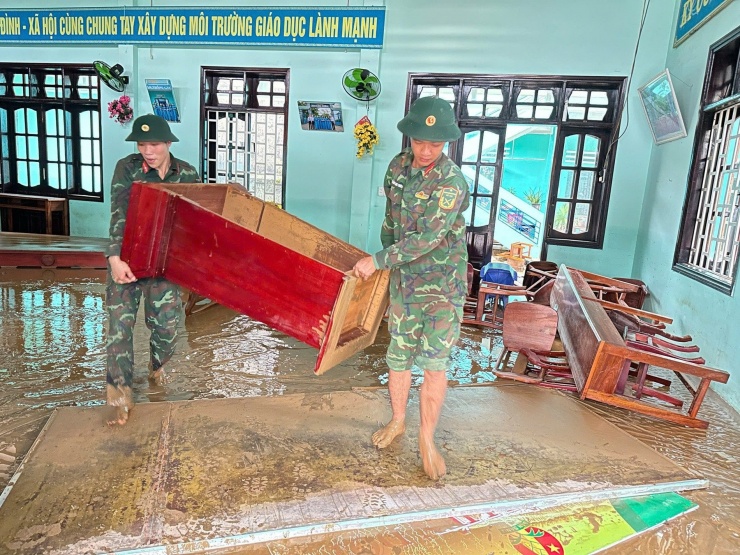 Tại Trường Tiểu học Hoàng Diệu, bàn ghế, lớp học lấm lem bùn. Ảnh: G.X