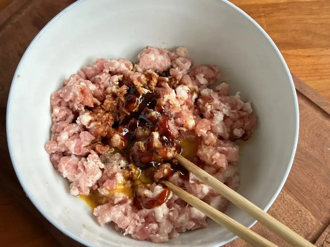 Trộn thịt bằm với một ít gia vị đã chuẩn bị sẵn, khuấy đều cho đến khi thịt dẻo và có độ kết dính.