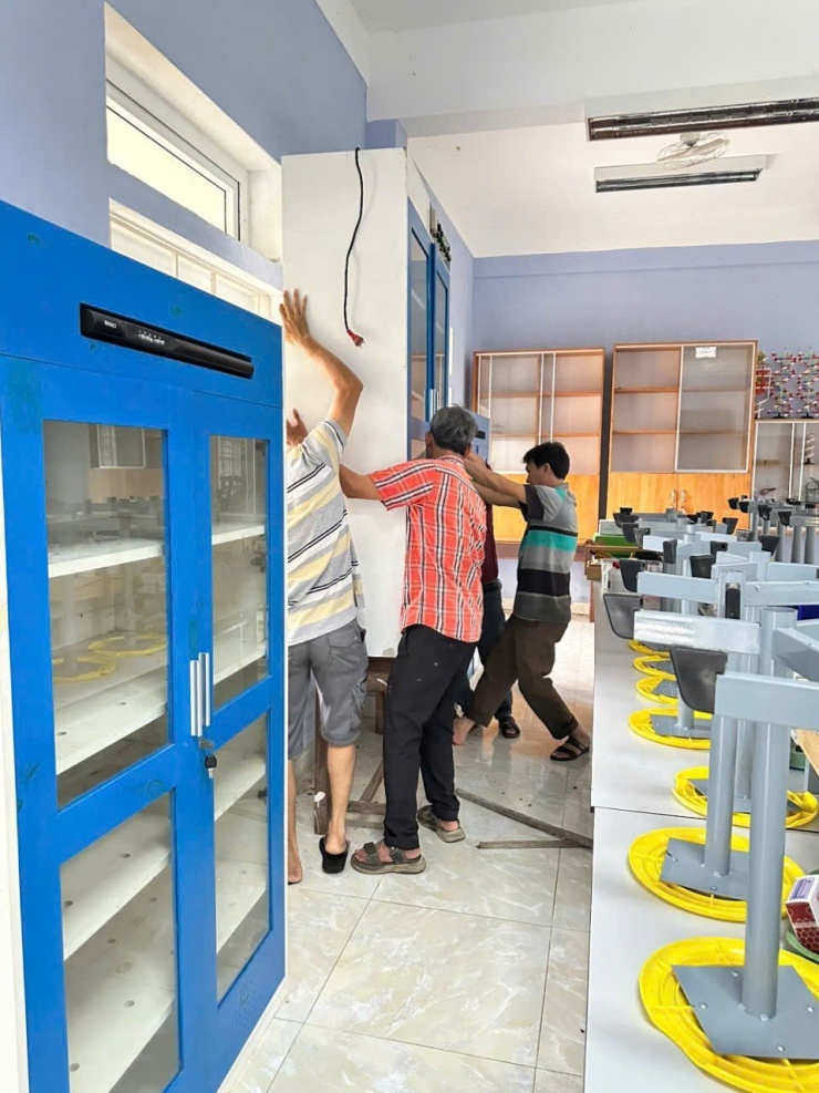 Các thầy giáo Trường THCS Ngô Thế Lân - xã Quảng Điền đang sửa chữa lại các trang thiết bị sau lũ rút- Ảnh Minh Hà