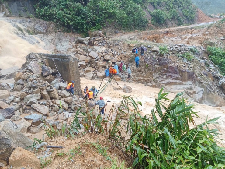 Lực lượng chức năng làm cầu treo bắc qua suối để sản phụ qua khu vực sạt lở. Ảnh: Phước Sơn Đài