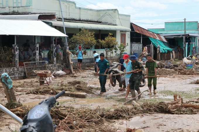 Lực lượng chức năng khiêng xe máy bị cuốn trôi của người dân lên đường. Ảnh: Việt Quốc