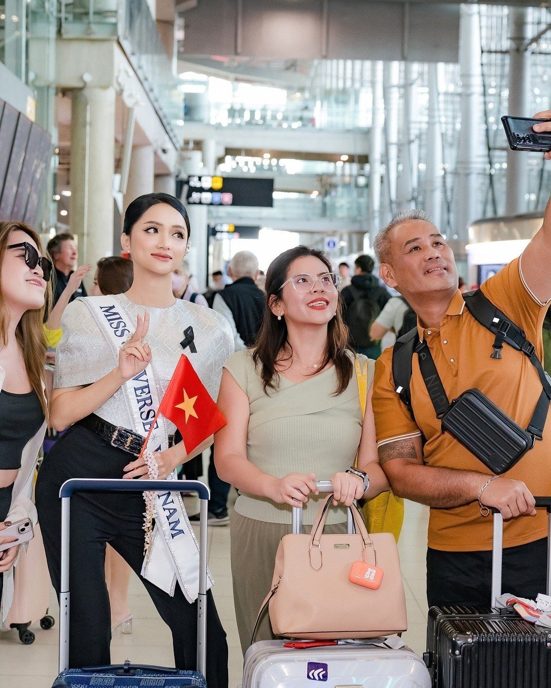 Hoa hậu Hương Giang vui vẻ chụp ảnh cùng khách du lịch yêu mến cô tại sân bay.