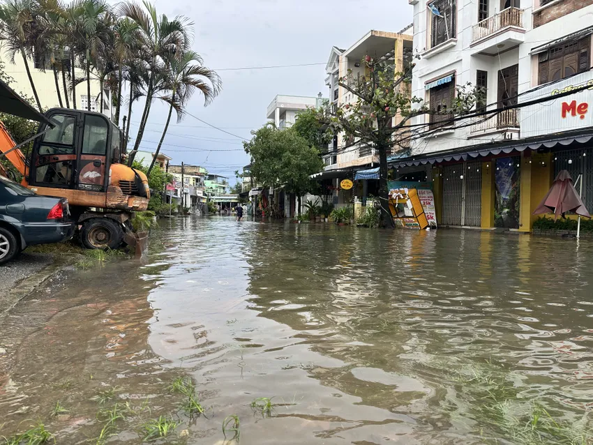 Ngã tư Trần Dư - Huỳnh Thúc Kháng ngập sâu, lực lượng chức năng giăng dây cấm người dân qua lại. Ảnh: TN