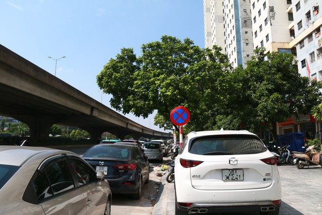 Các phương tiện đỗ tràn lan dưới lòng đường và trên vỉa hè dù có biển báo cấm đỗ.