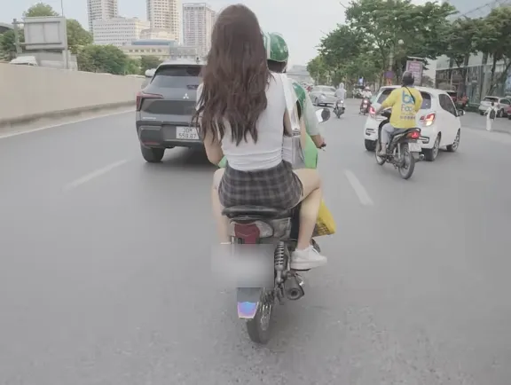 Để người ngồi phía sau không đội mũ bảo hiểm thì cả người ngồi phía sau xe và người lái xe đều bị xử phạt. Ảnh: MXH