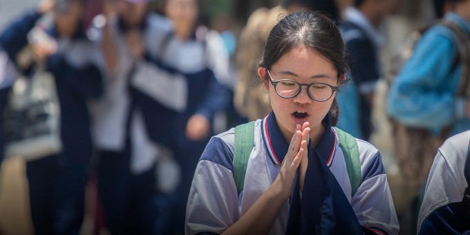 Một học sinh cầu nguyện sau khi làm bài thi tuyển sinh trung học phổ thông tại Quảng Châu, tỉnh Quảng Đông, tháng 6/2018. Ảnh: Tan Qingju/Southern Metropolis Daily/VCG