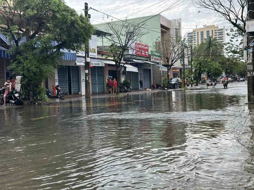 Ngã tư Trần Dư - Huỳnh Thúc Kháng ngập sâu, lực lượng chức năng giăng dây cấm người dân qua lại. Ảnh: TN